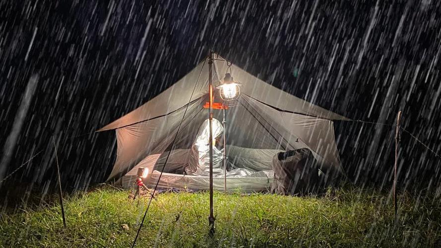 暴雨中露营艰难地在雨中搭建塑料帐篷